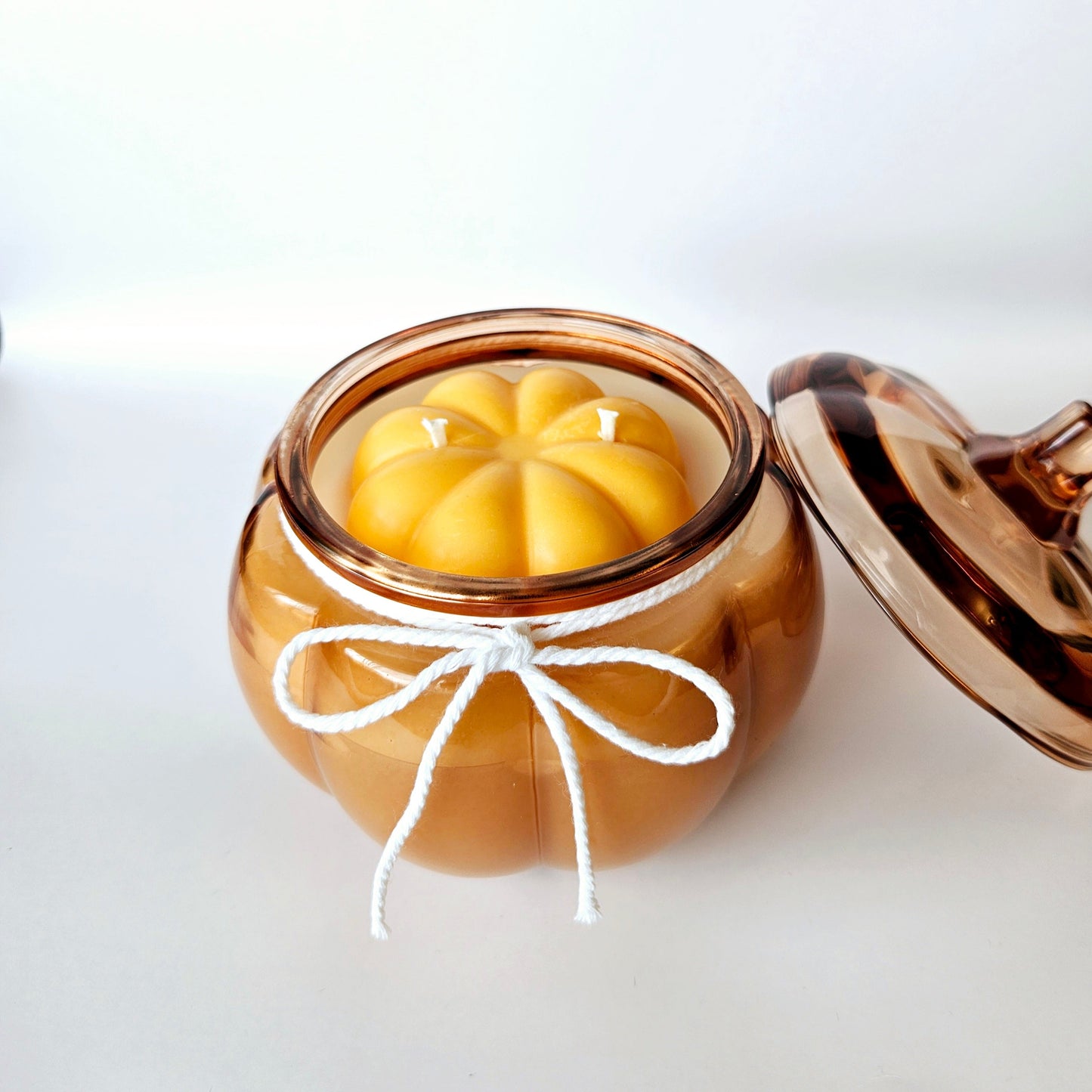Pumpkin jar with a pumpkin shape candle inside on a white background