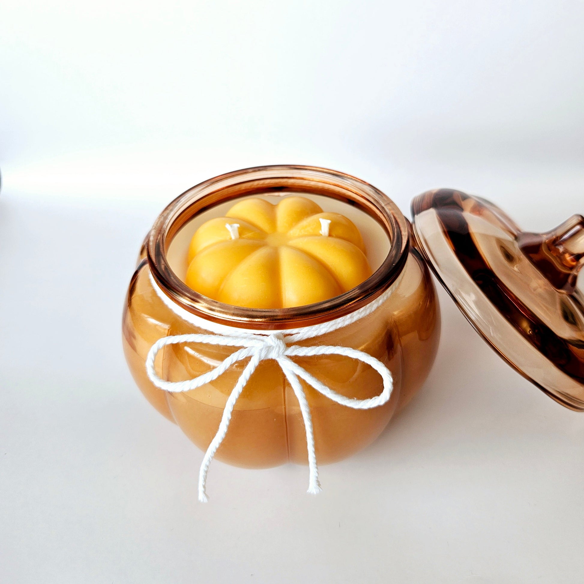 Pumpkin jar with a pumpkin shape candle inside on a white background